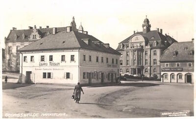 AK-Georgswalde-Marktplatz-mit-Kolonialwarengeschaeft-von-Eduard-Roessler.jpg